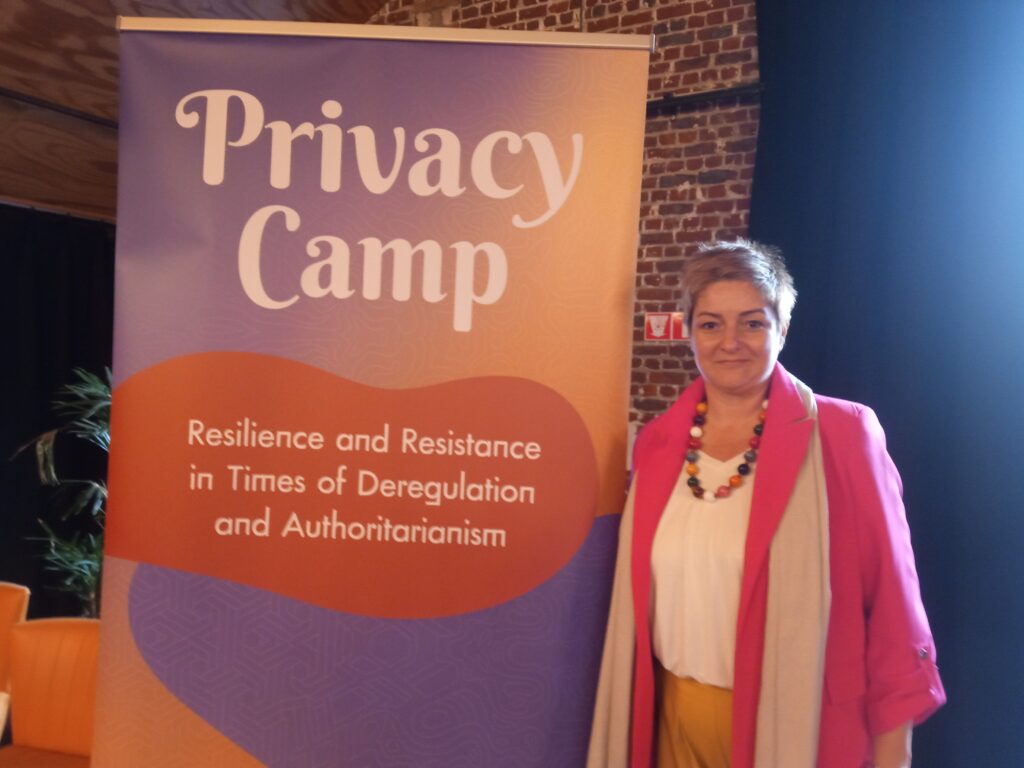 Woman standing next to Privacy Camp banner at Impetus event.