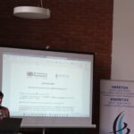 Woman presenting cybersecurity career guidance at Impetus event on youth cybersecurity pathways.