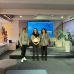 Three women standing on stage during Safer Internet practices exchange event.