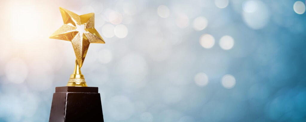 Golden star trophy on a black base with a blurred background.