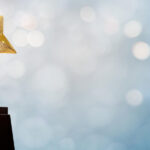 Golden star trophy on a black base with a blurred background.